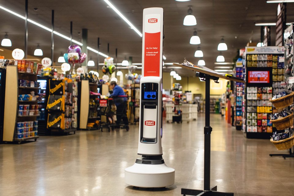 Shelf-scanning robot in a supermarket aisle.
